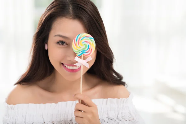Woman, covering her eye with lollipop — Stock Photo, Image