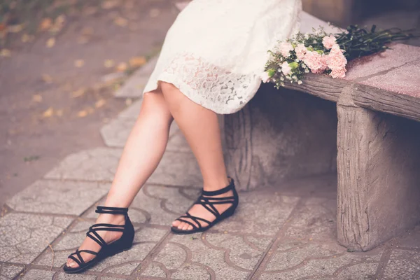 Legs of woman sitting on bench — Stock Photo, Image