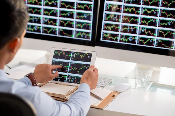 Broker analyzing stock market diagrams — Stock Photo, Image