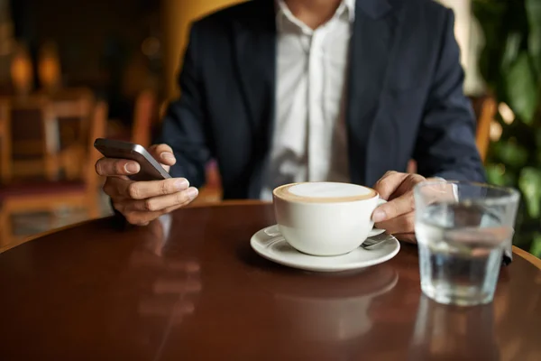 Businessman drinking cappuccino — Stock Photo, Image