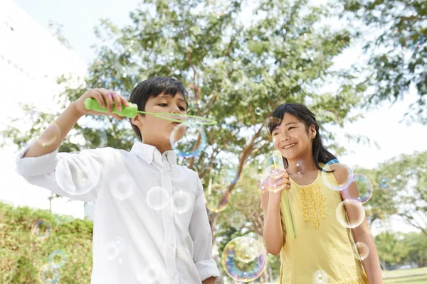 Kinder pusten Seifenblasen — Stockfoto