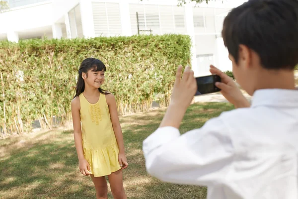 少年は、彼の妹の写真を撮影 — ストック写真