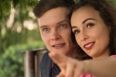 Adam kız arkadaşına bir şey gösteriyor.