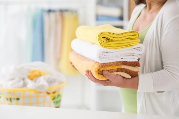 Woman carrying bath towels — Stock Photo, Image