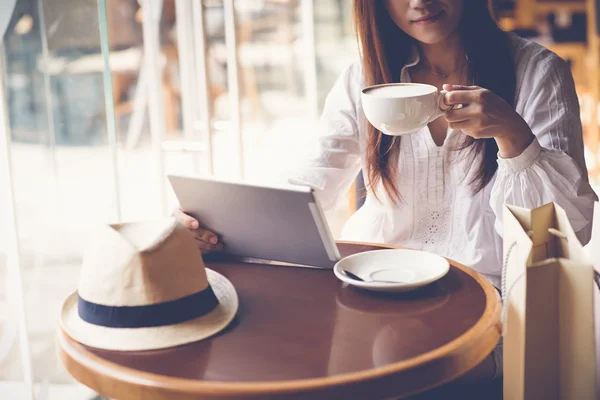 Γυναίκα με ψηφιακή δισκίο πίνοντας καφέ — Φωτογραφία Αρχείου