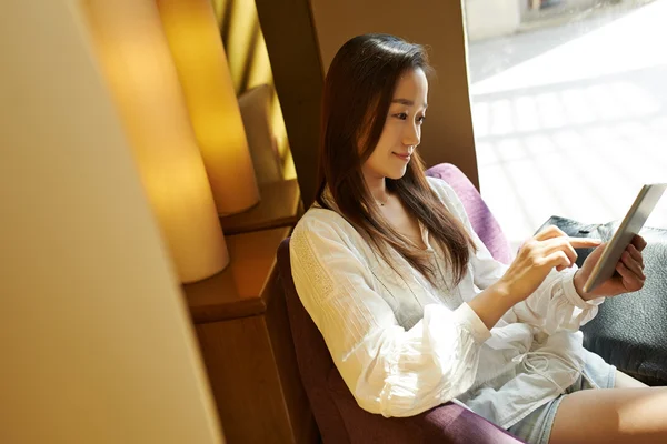 Vrouw zitten en het gebruik van tablet pc — Stockfoto