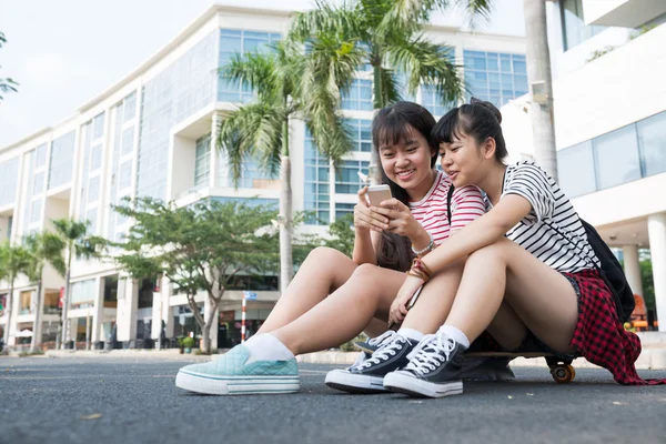 Девочки-подростки сидят на скейтборде — стоковое фото