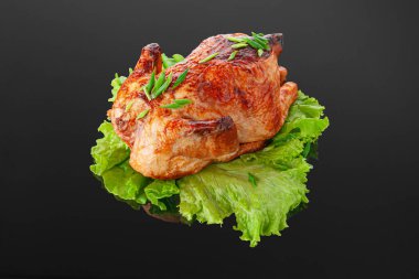 Marul yaprağında ızgara tavuk. Yeşillikle süslenmiş. Yakın plan. Koyu ayna arkaplanı.