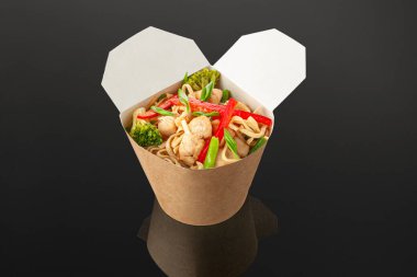 Soba erişteli waok, tavuk fileto ve sebze. Nakliye kutusunda. Karanlık arka plan. İzole edilmiş. Yakın plan. Yukarıdan görüntüle.