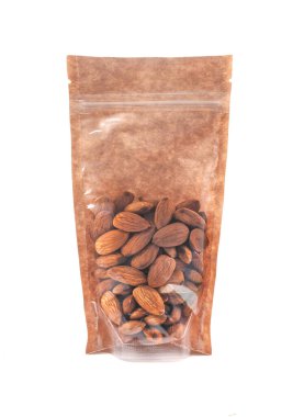 Kahverengi bir kesekağıdındaki bademler. Toptan ürünler için plastik pencereli bir paket. Yakın plan. Beyaz arka plan. İzole edilmiş.