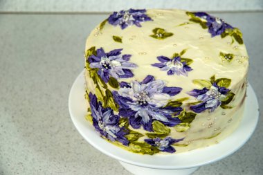 Mor çiçekli bisküvi kremalı pasta.