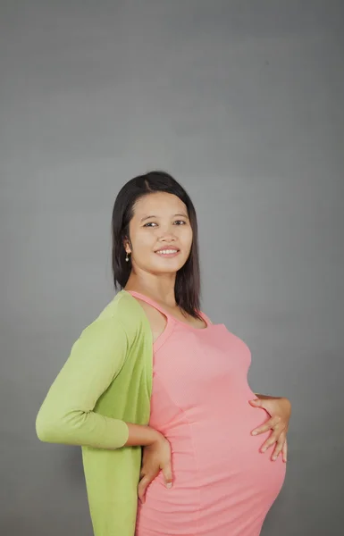 Kobieta w ciąży na białym tle szarym tle Zdjęcie Stockowe