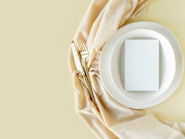 Şenlikli düğün ya da doğum günü sofrasında altın çatal bıçak, porselen tabak ve dekoratif tekstil. Boş bir model. Restoran menü şablonu. Düz yatış, üst görünüm. 