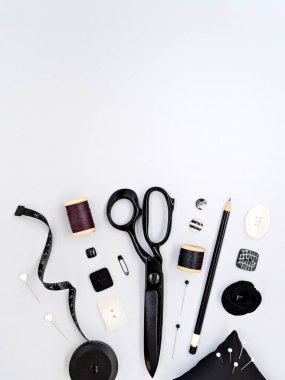 Çeşitli zanaat ve dikiş aletleri. Makas, düğmeler, raptiyeler ve ölçüm bandı gri arka planda fotokopi alanı ile duruyor. Alt sınır çerçevesi, iş tasarımı için modelleyin.