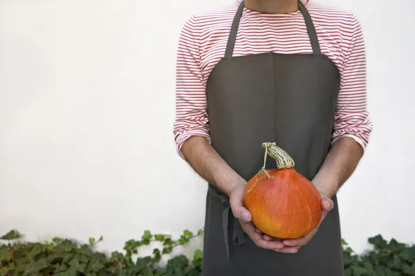 Boer bedrijf oranje pompoen. — Stockfoto