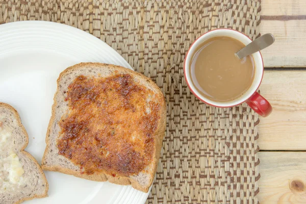 Coffee and toasts with spread on wooden table