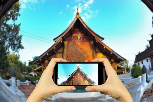 Lung Phra Bang, Laos. Taking photo on smart phone concept.