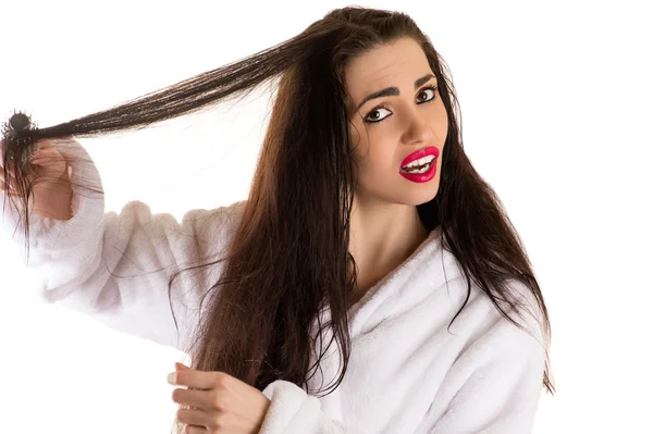 Привлекательная женщина расчесывает волосы с грустным лицом — стоковое фото