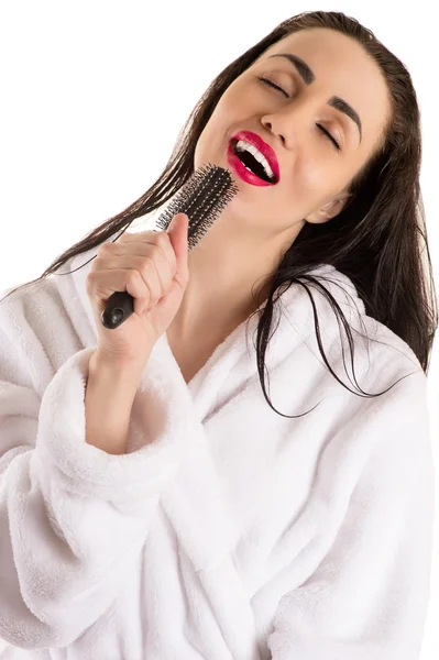 Mulher atraente com cabelo molhado cantando em escova de cabelo — Fotografia de Stock