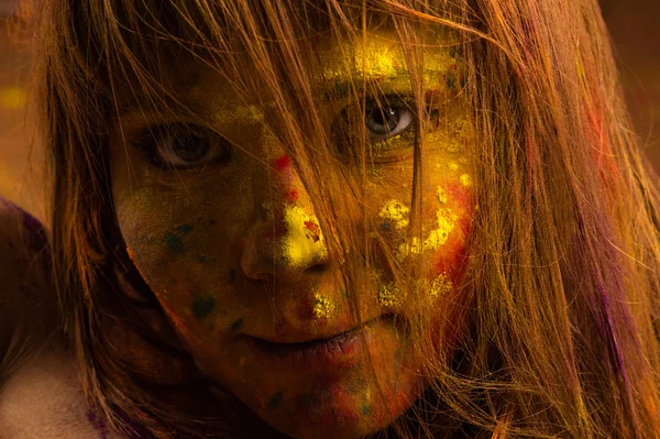 Gezicht van de vrouw in de kleuren van Holi closeup — Stockfoto