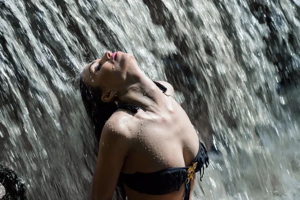 Krásná žena v toku vodopád — Stock fotografie