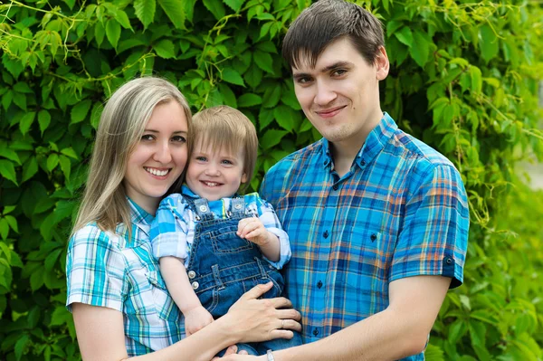 Gelukkige familie op achtergrond van groene hedge — Stockfoto