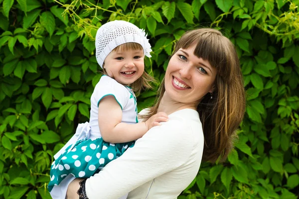 Retrato sonriente madre con una hija en las manos — Foto de Stock