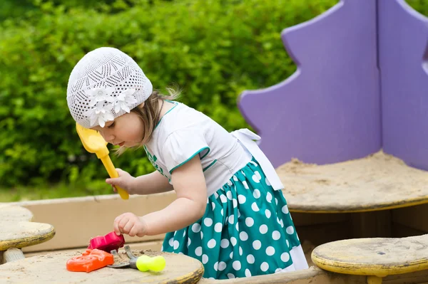 Menina criança brincando na caixa de areia no playground — Fotografia de Stock