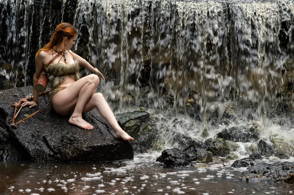 Молодая женщина лучник наслаждается водопадом — стоковое фото