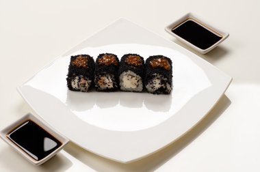 siyah havyar ile daireler ile beyaz bir plaka üzerinde rulo