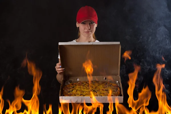 Молодая девушка с коробкой пиццы в огне — стоковое фото