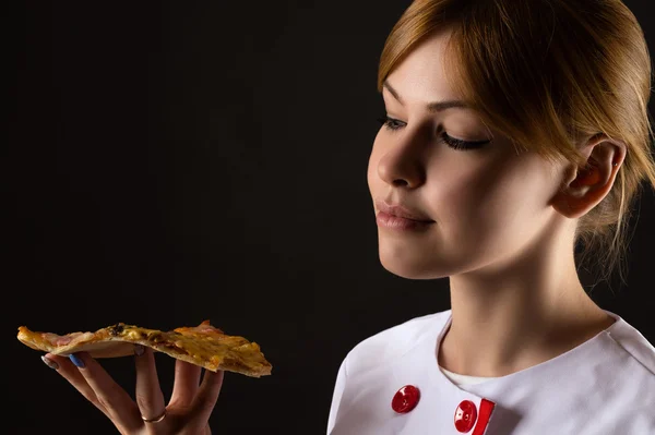 Aantrekkelijke chef-kok op zoek plak van pizza — Stockfoto