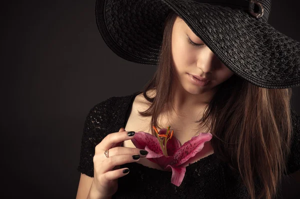 Korean teenager girl with lily flower isolated on black — Stock Photo, Image