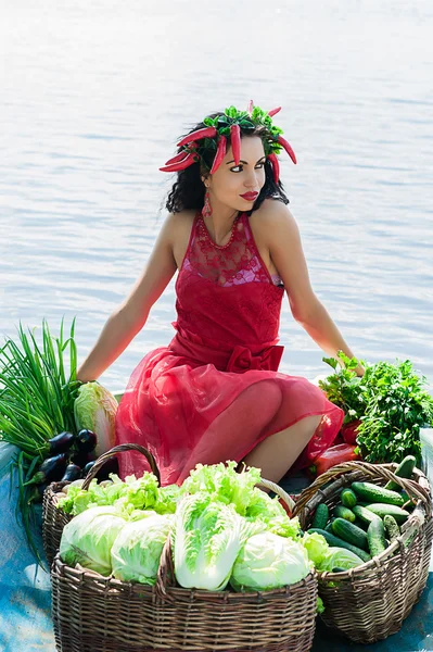 Mulher com legumes em um barco na água — Fotografia de Stock