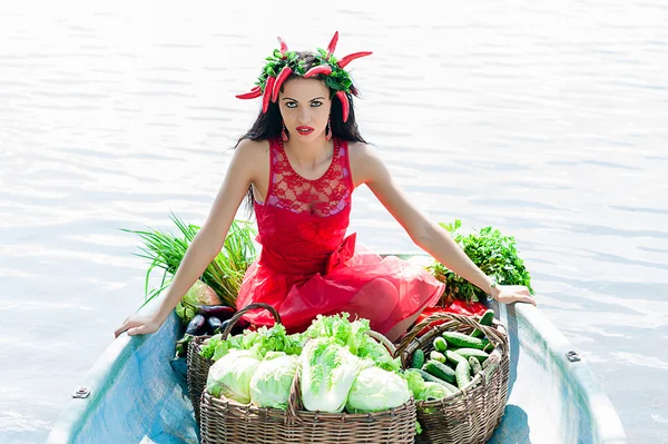 Beautiful woman with vegetables in a boat — Stock Photo, Image