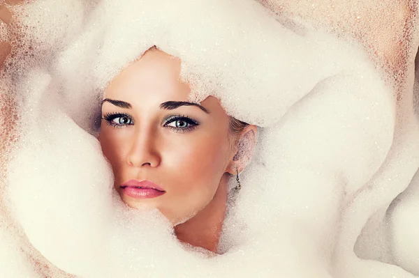 Portrait of a beautiful blond woman in the foam — Stock Photo, Image