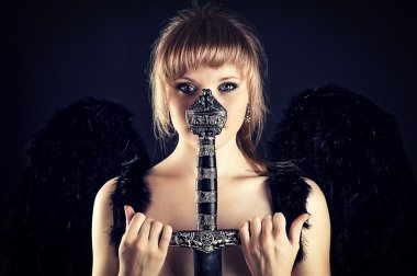 Kadın siyah kanatlar ve kılıç kabzası ile