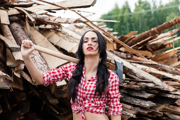 Sexy woman ax in hand in a plaid shirt — Stock Photo, Image