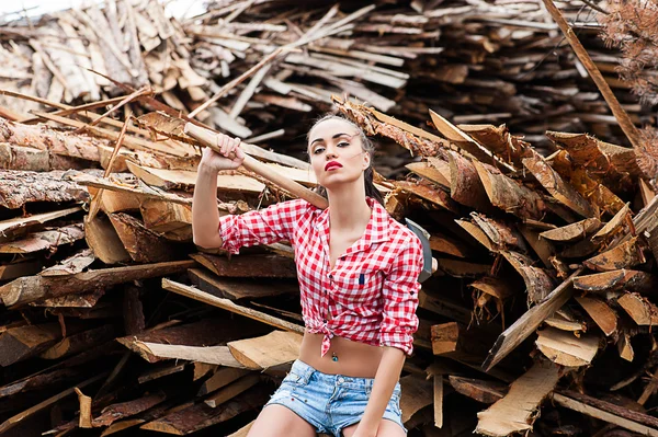 Mujer hacha en la mano en una camisa a cuadros —  Fotos de Stock