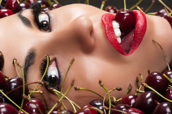 Beautiful face in cherry closeup — Stock Photo, Image