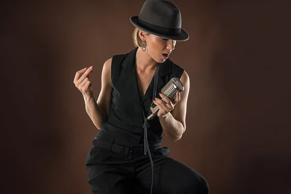 Stylish woman in a hat with a retro microphone — Stock Photo, Image
