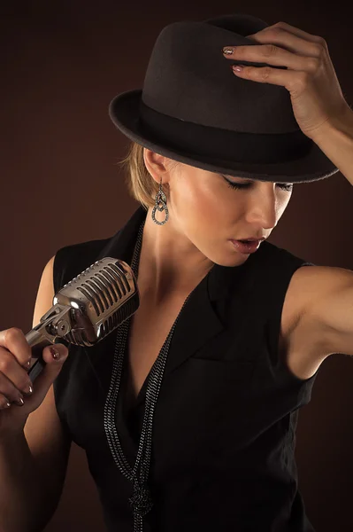 Woman in a hat with a retro microphone — Stock Photo, Image