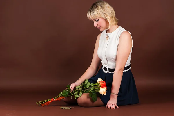 Attraktive Frau in Depressionen mit einem Strauß Rosen — Stockfoto