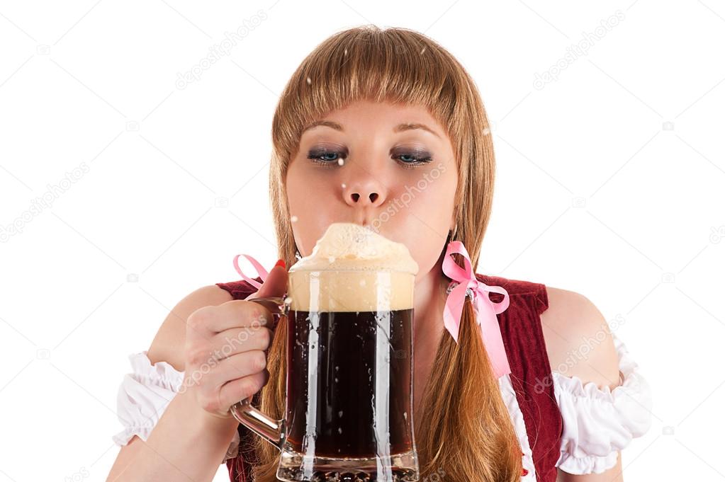 Oktoberfest waitress blows with beer foam isolated on white