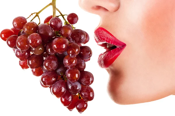 Mulher sexy comendo uvas vermelhas, lábios vermelhos sensuais — Fotografia de Stock