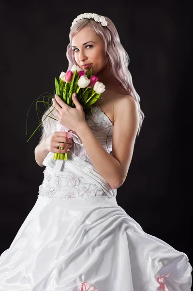 Счастливая невеста в свадебном платье с букетом тюльпанов — стоковое фото