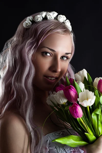 Mode kvinna ansikte med en bukett tulpaner — Stockfoto