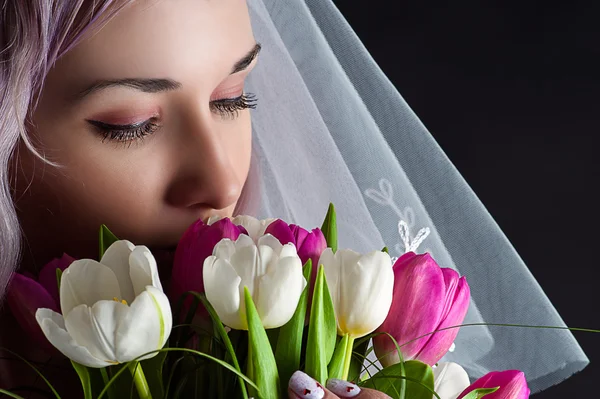 Beautiful woman face with a bouquet of tulips — Stock Photo, Image