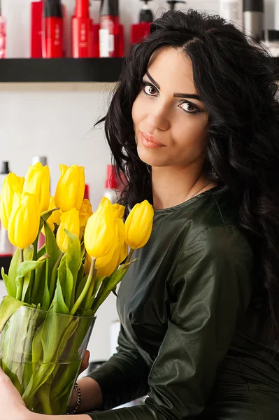 Okouzlující žena kudrnaté vlasy s žluté tulipány — Stock fotografie