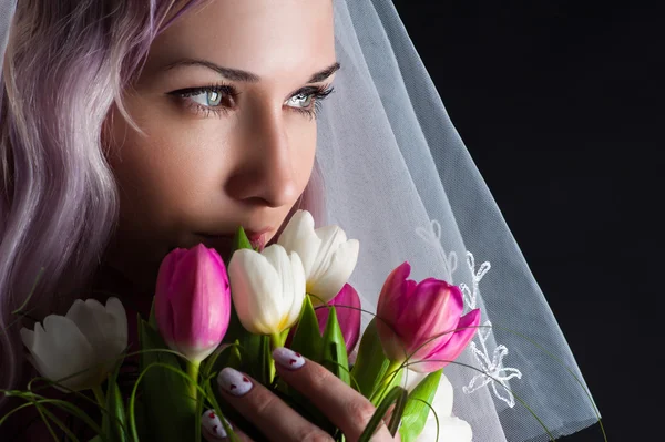 Kvinnan ansikte med en bukett tulpaner — Stockfoto